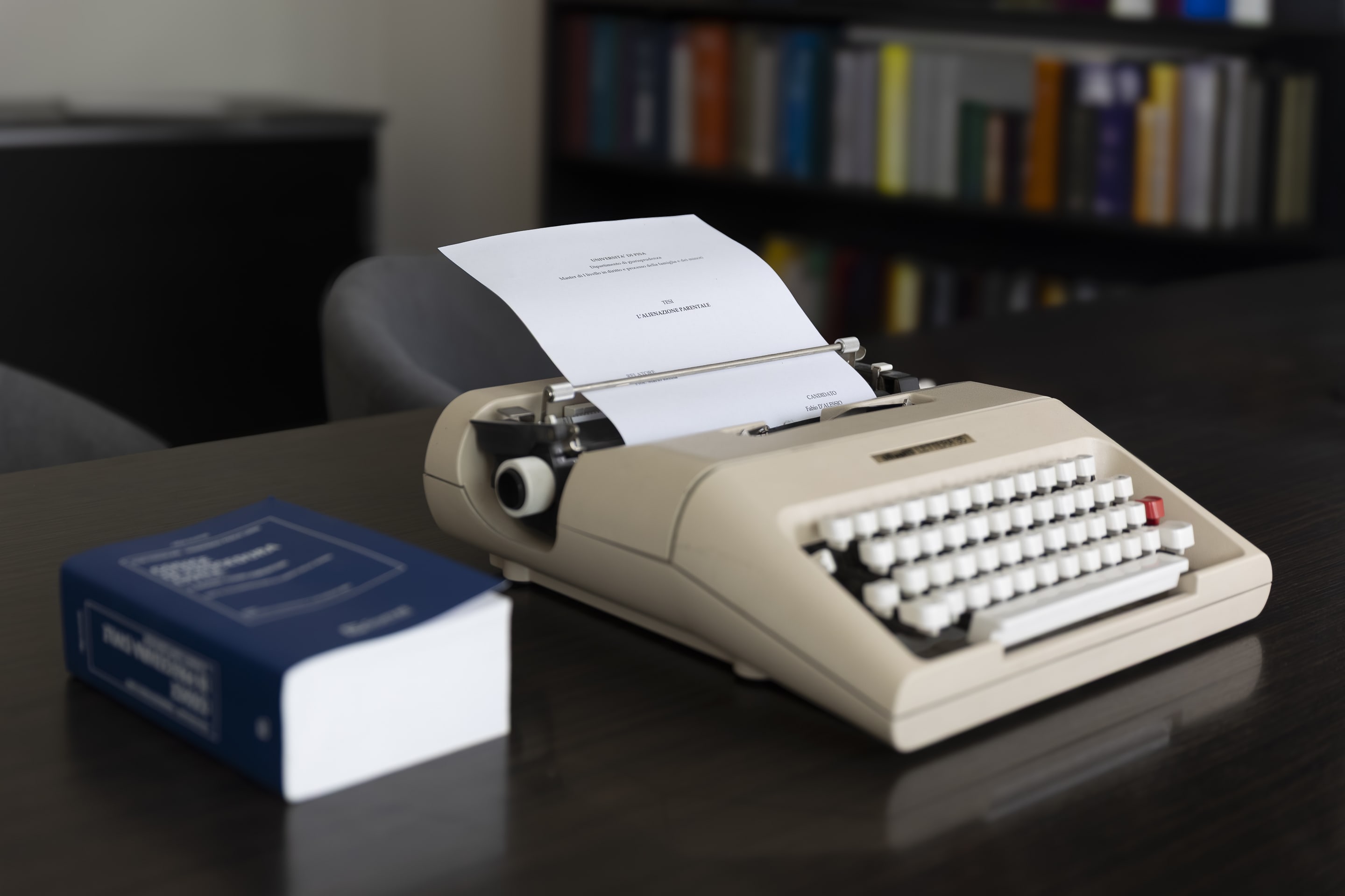 Macchina da scrivere vintage con testo giuridico e biblioteca sullo sfondo